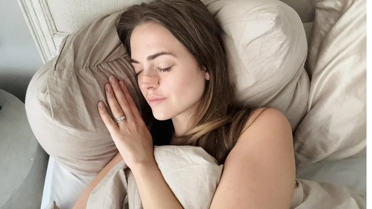 Woman asleep on a pillow wearing a nasal strip